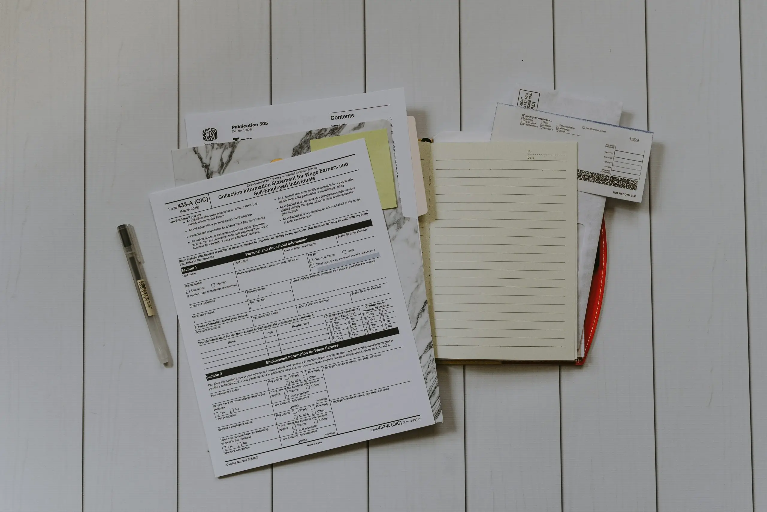 A pile of tax documents with folders and papers scattered.