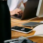 A busy office desk with a calculator, pen, and financial documents.
