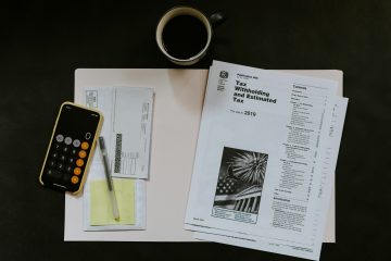 A table with a calculator, financial documents, and a coffee cup.