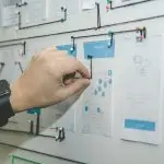 A hand placing a document into a filing cabinet.
