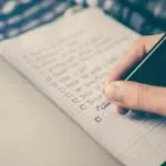 A person writing in a notebook.