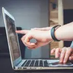 A person using a laptop for online tax management.