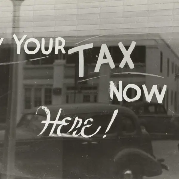 A signboard saying “Pay Your Tax Now.”