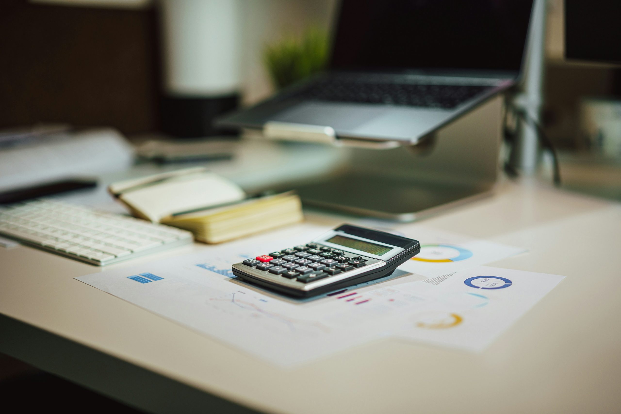 A financial desk setup with a calculator, documents, and digital elements.